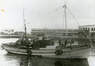Embarcaci&oacute;n con 12 homes &aacute; bordo co Berb&eacute;s ao fondo (Vigo, 1963)