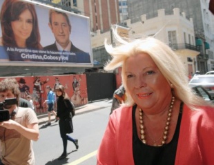 Elisa Carri&oacute; pasa por diante dos carteis electorais do Frente para la Victoria